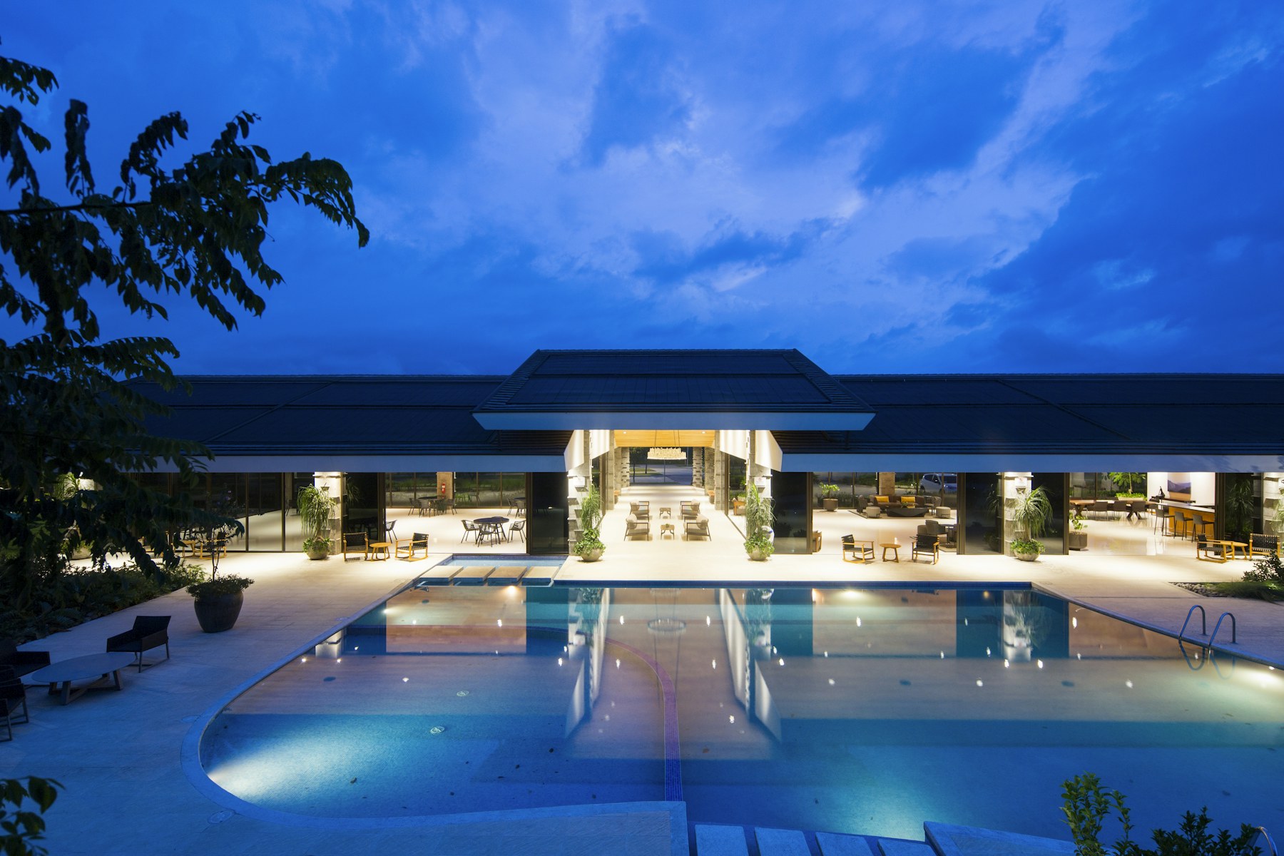 A welcoming hotel beside a pool at dusk